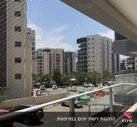 מרפסת עם רשת הגנה נגד יונים בבניין מגורים